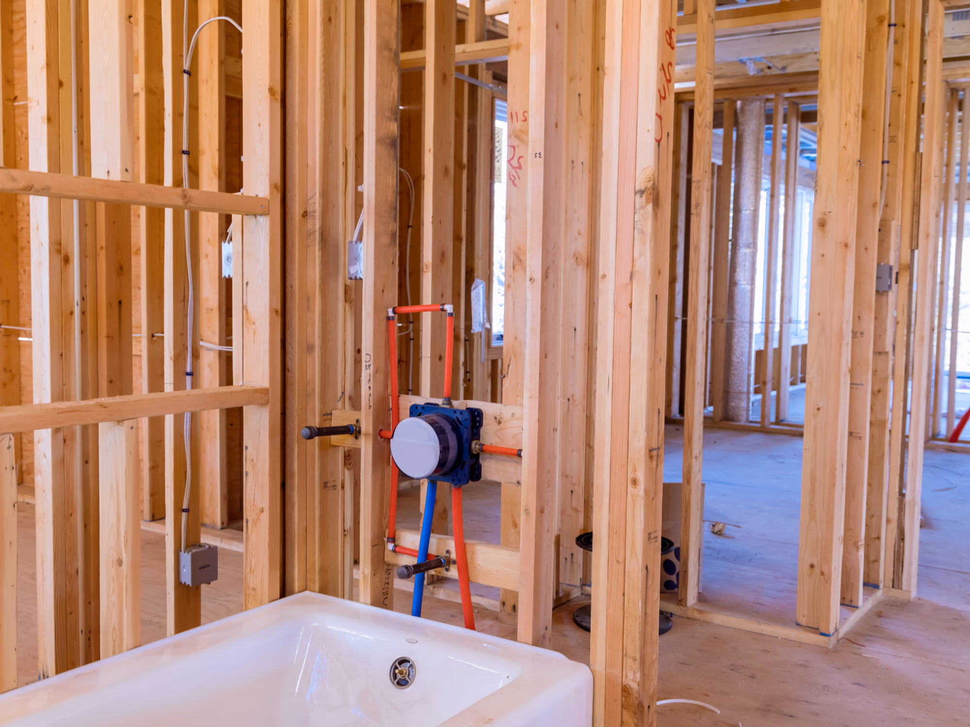 Basement bathroom plumbing installation for bathtub during renovation framing