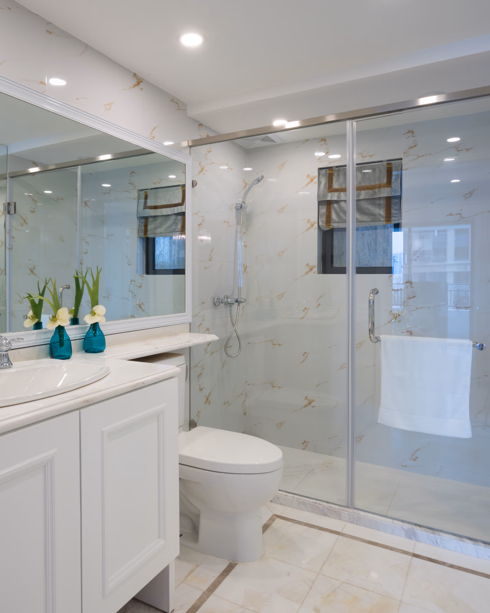 Modern basement bathroom renovation with marble tile shower and white vanity