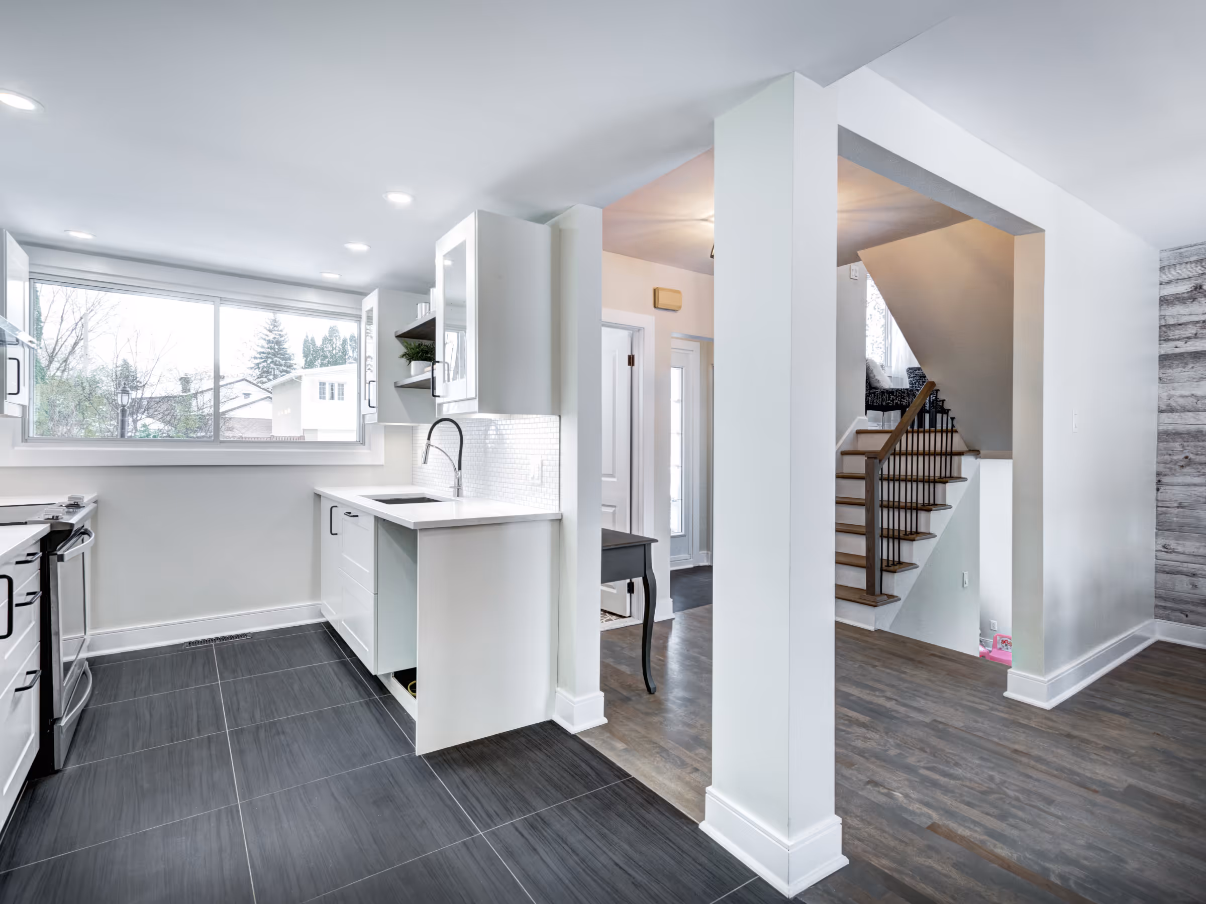 Bright basement kitchen renovation with modern cabinets and large window
