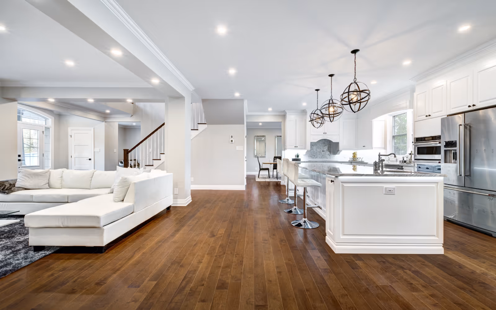 Basement kitchen renovation with dark island, built-in microwave, and bar seating