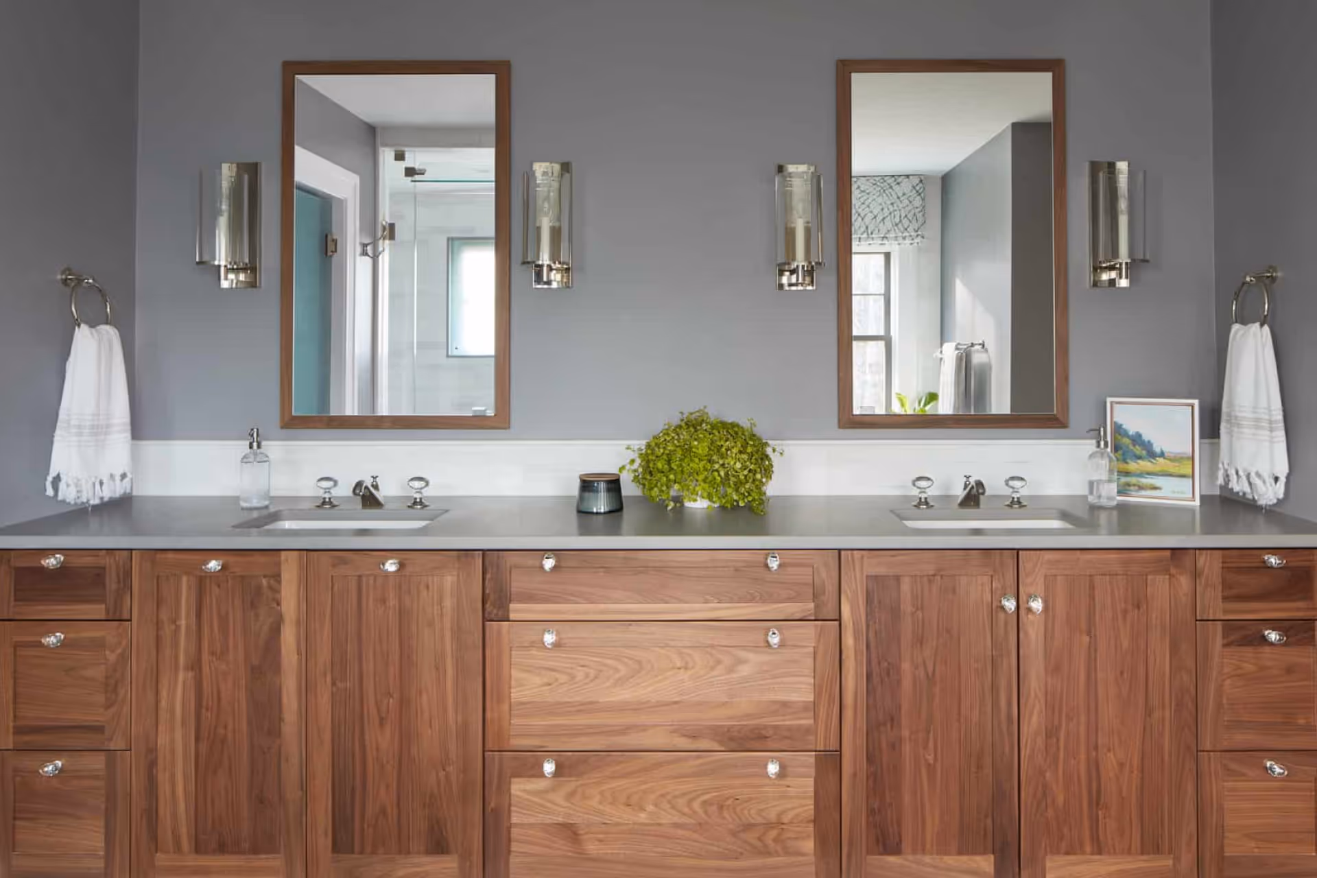 Modern double-sink bathroom vanity renovation with wood cabinetry and updated lighting
