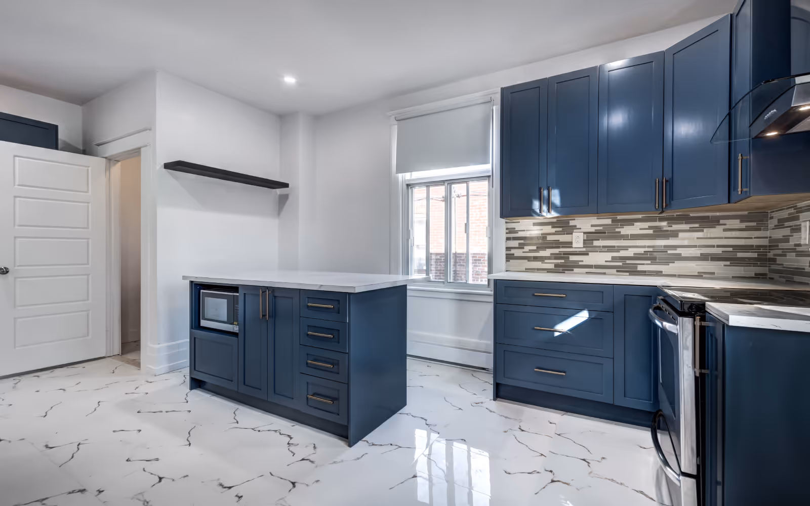 Kitchen renovation with marble-look tile flooring, blue cabinetry, and island