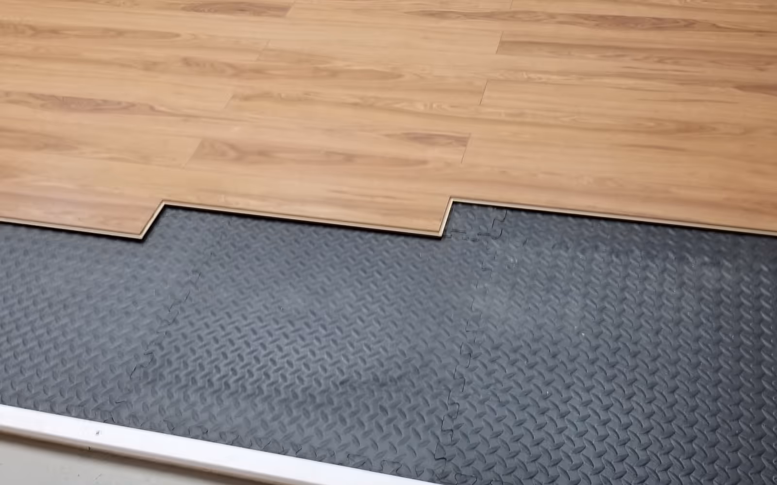 Laminate plank flooring installation over underlayment with click-lock seam