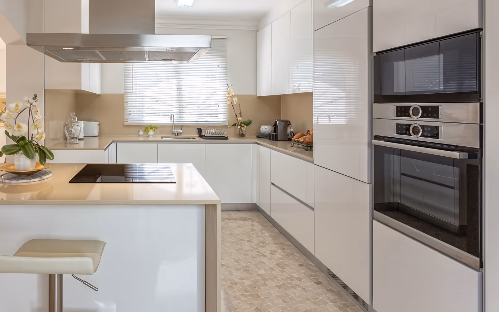Kitchen appliance installation with built-in wall ovens and modern cooktop island