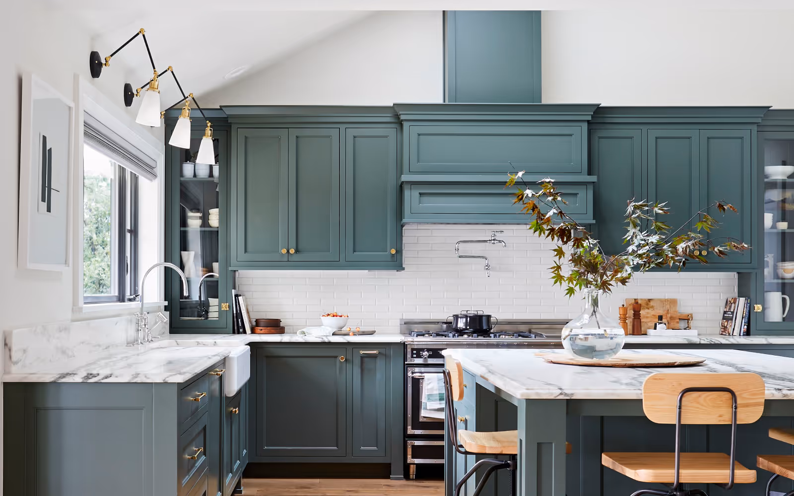 Custom kitchen cabinets with brass hardware and stone countertops in modern remodel