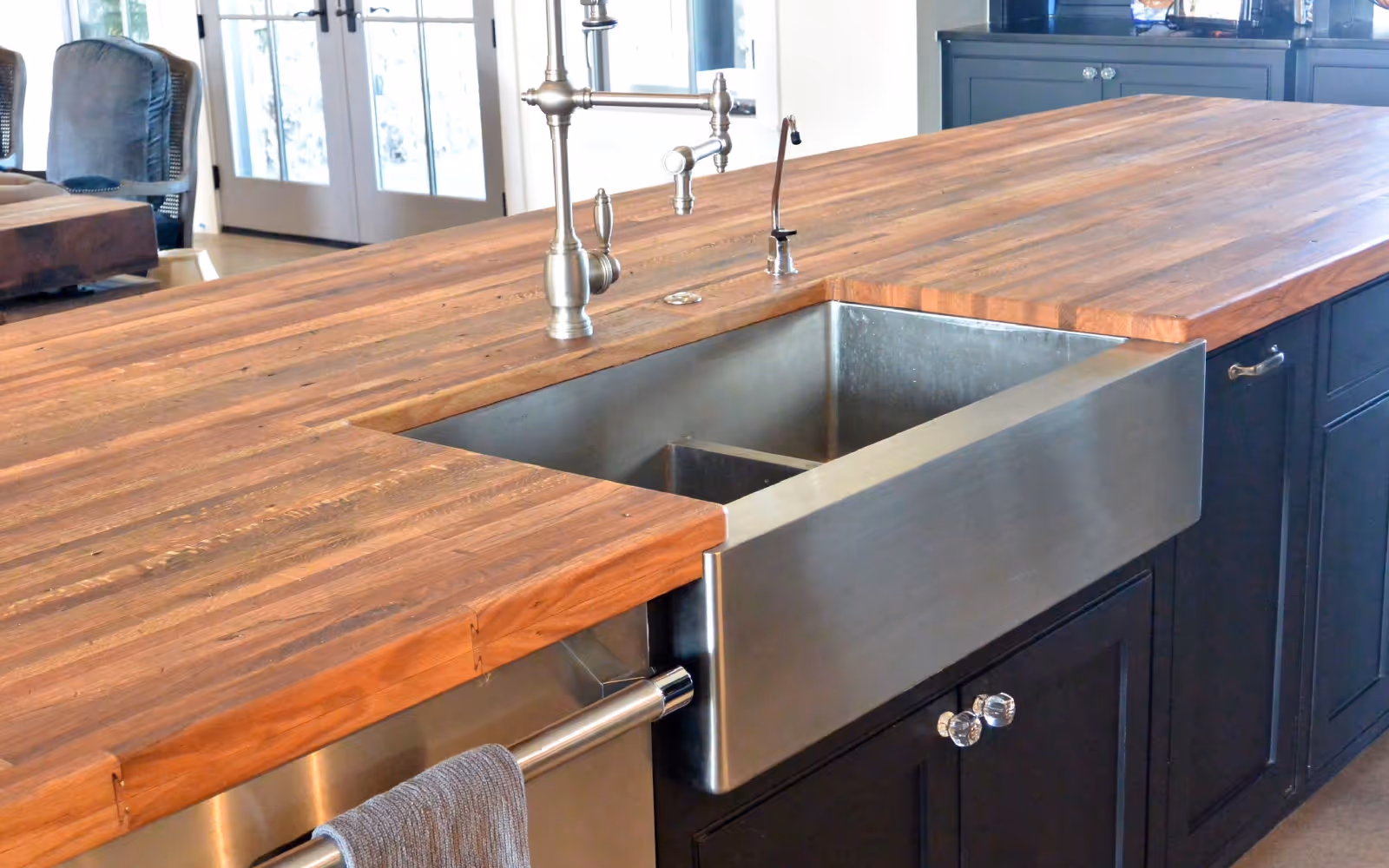 Butcher block kitchen countertop with apron-front sink and gooseneck faucet