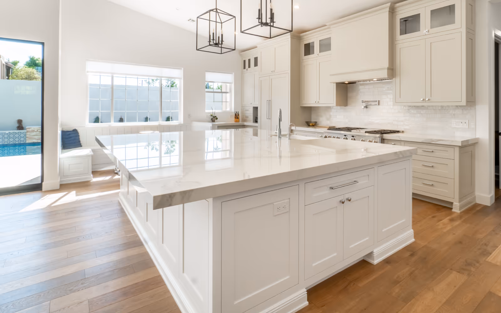 Large quartz kitchen island and bright white cabinetry in a renovated kitchen