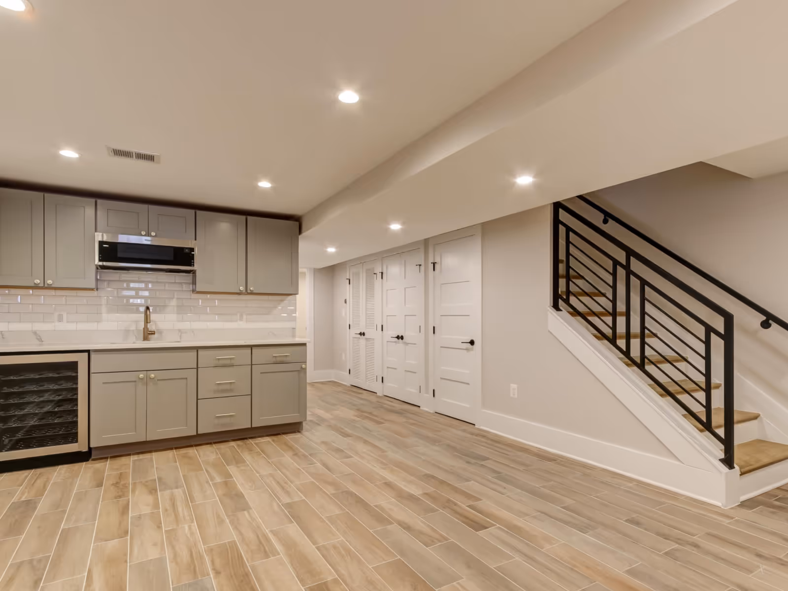 Whitby basement renovation with kitchenette, tile flooring, and modern stair railing