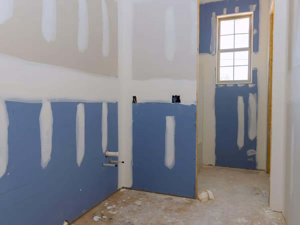 Basement bathroom drywall installation during renovation before finishing and painting