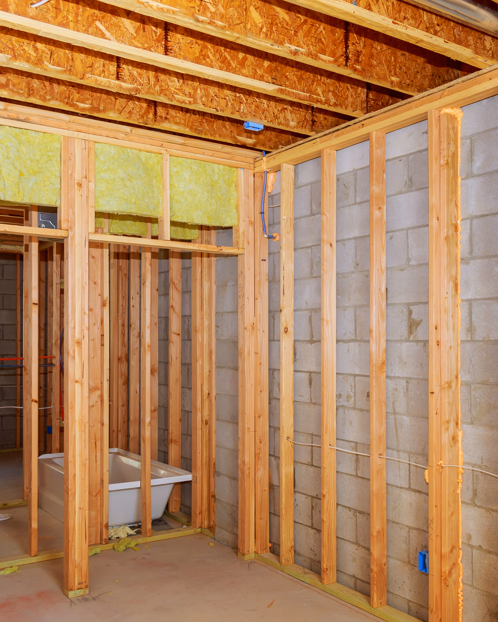 Basement bathroom framing with wood studs and insulation installation