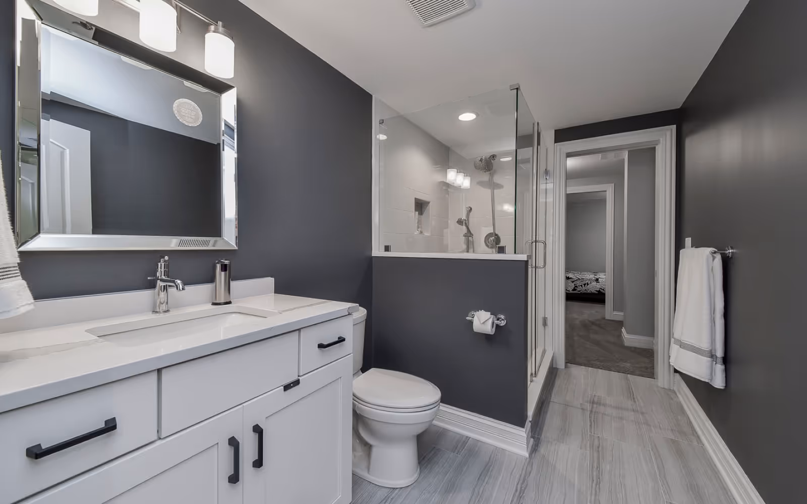 Basement bathroom renovation with freestanding tub, glass shower, and modern tile