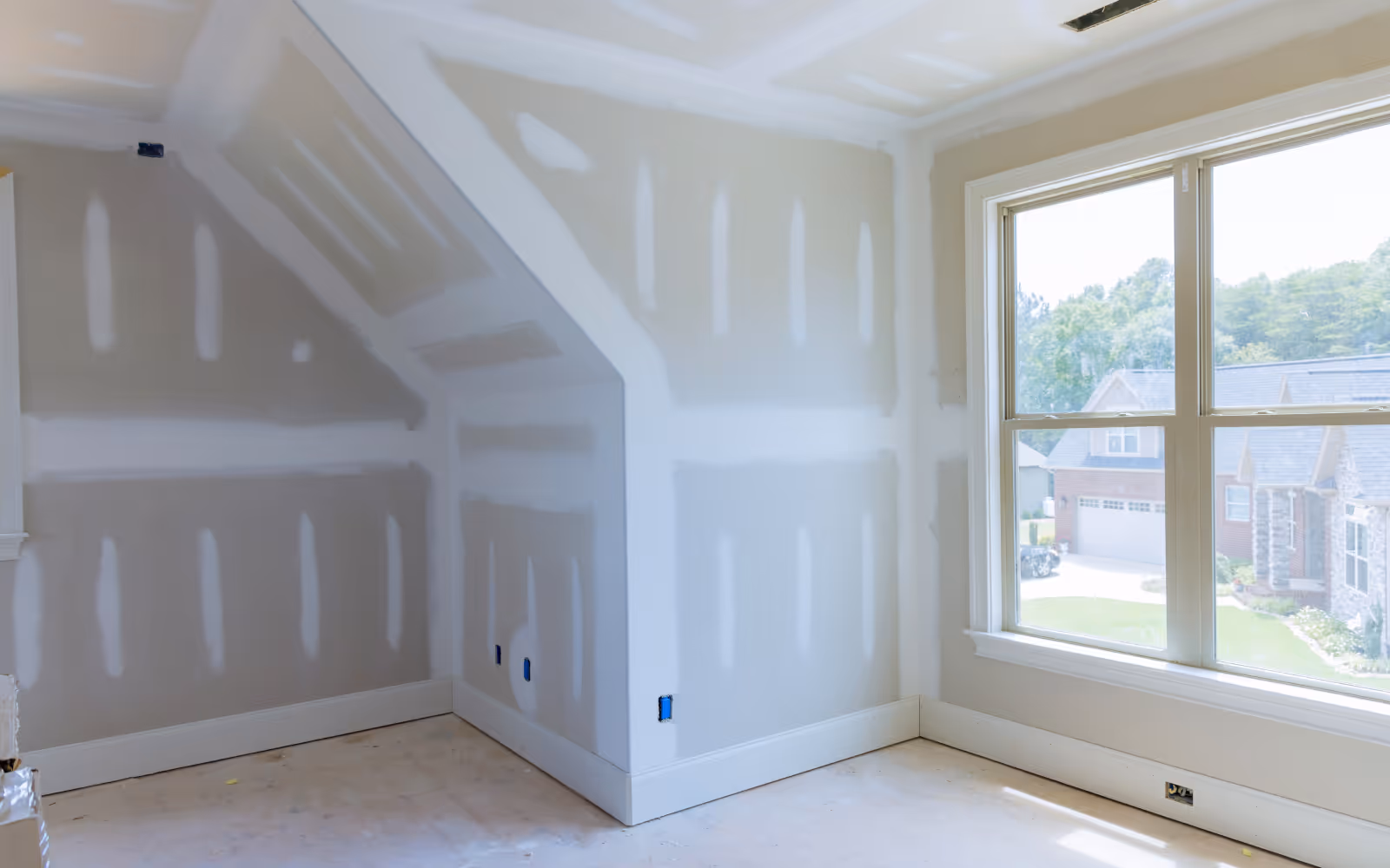 Basement drywall installation with taped joints and finishing prep around window and ceiling details