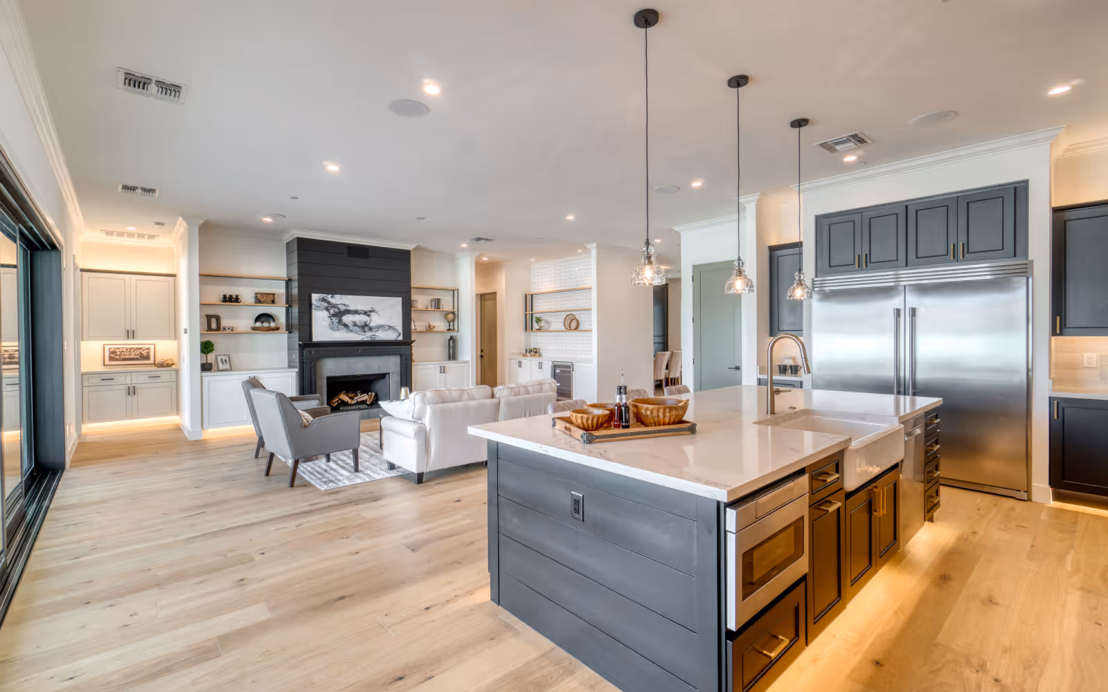 Open-concept kitchen renovation with large island, pendant lighting, and adjacent living space