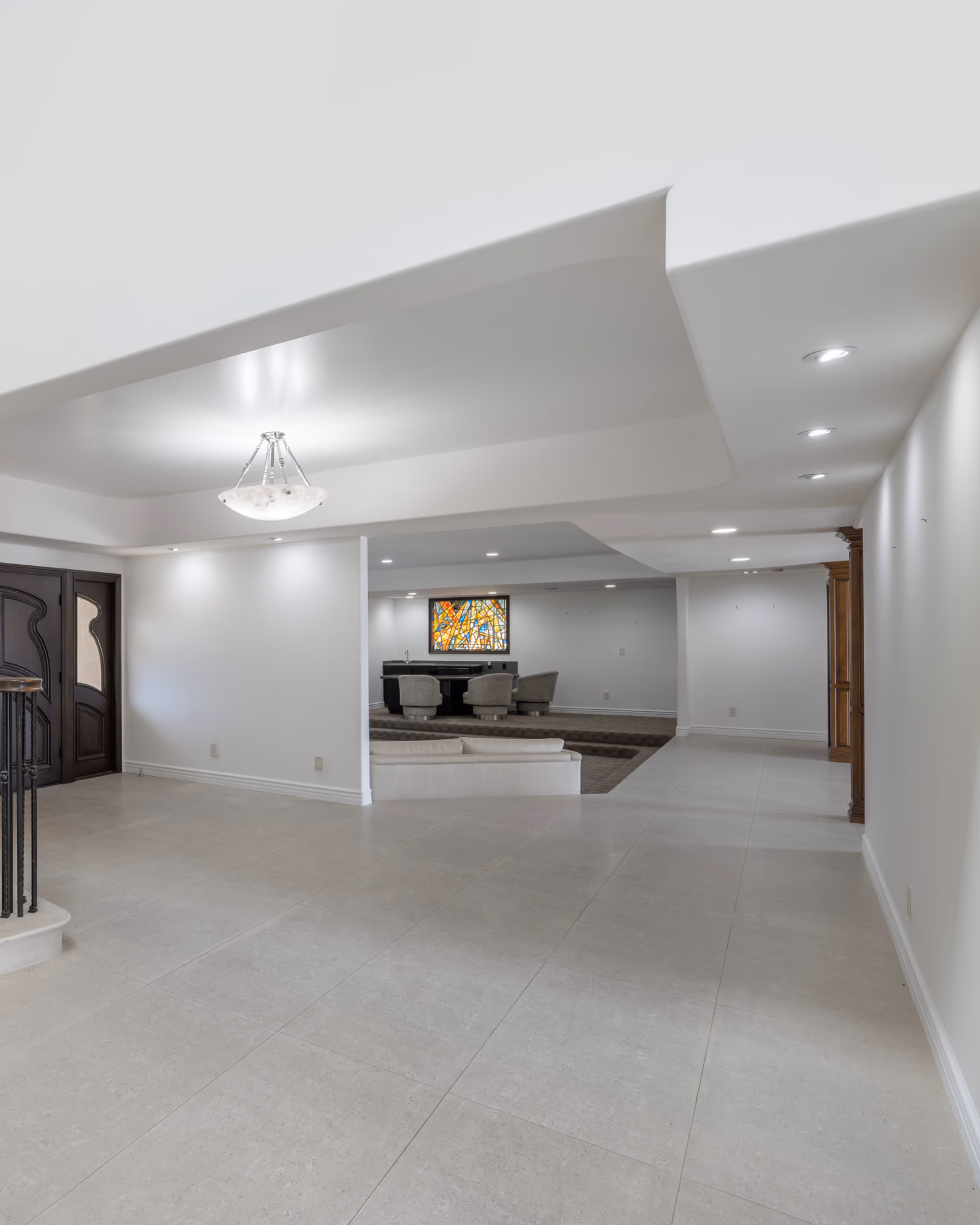 Finished basement painting with smooth white walls and recessed ceiling lighting