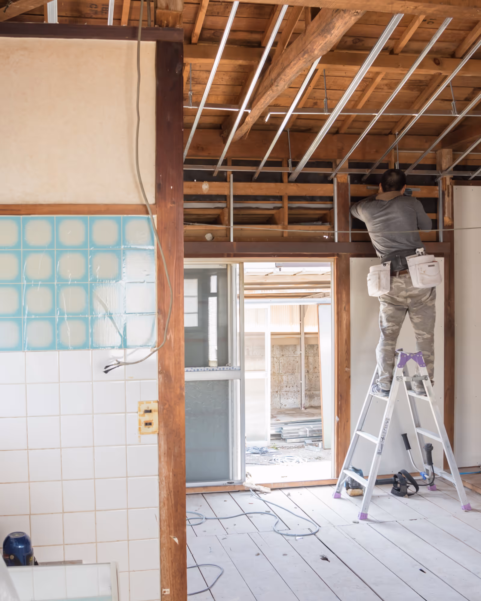 Basement remodel rough-in stage with exposed framing, ceiling channels, and on-site installation work