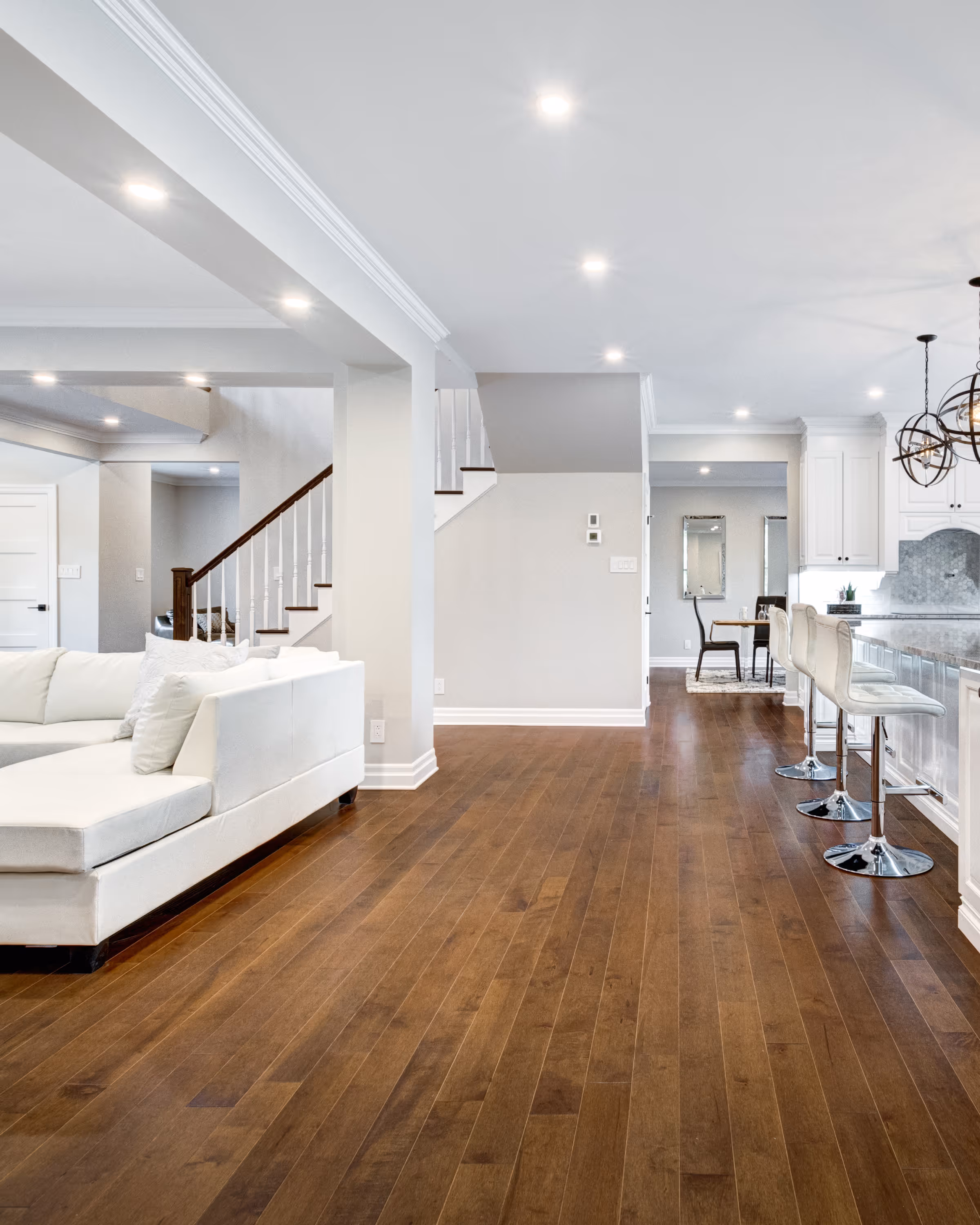 Open-concept finished basement renovation with hardwood floors, recessed lighting, and bar seating