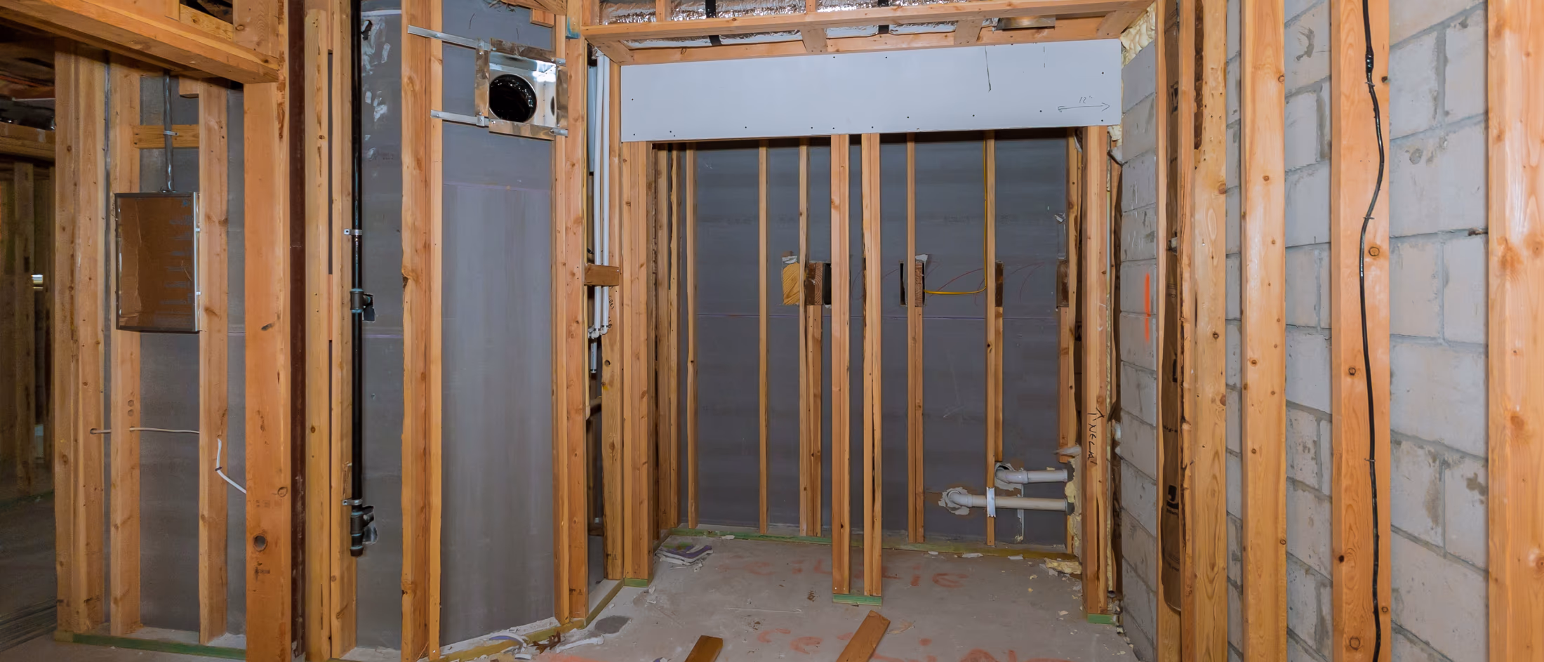 Finished basement wall framing with wood studs ready for drywall