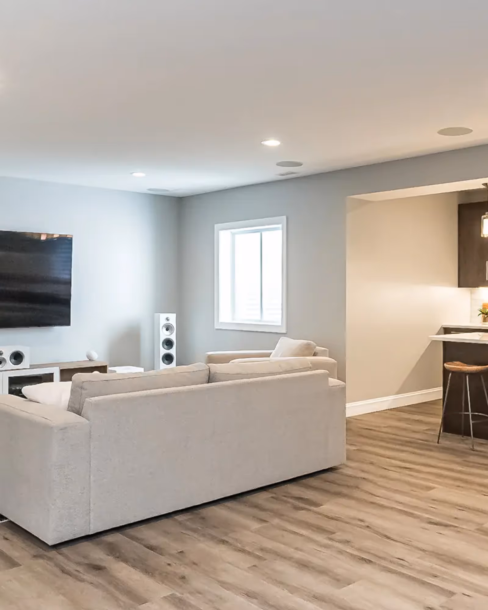 Basement stair renovation with glass railing, bright white finishes, and luxury vinyl plank flooring