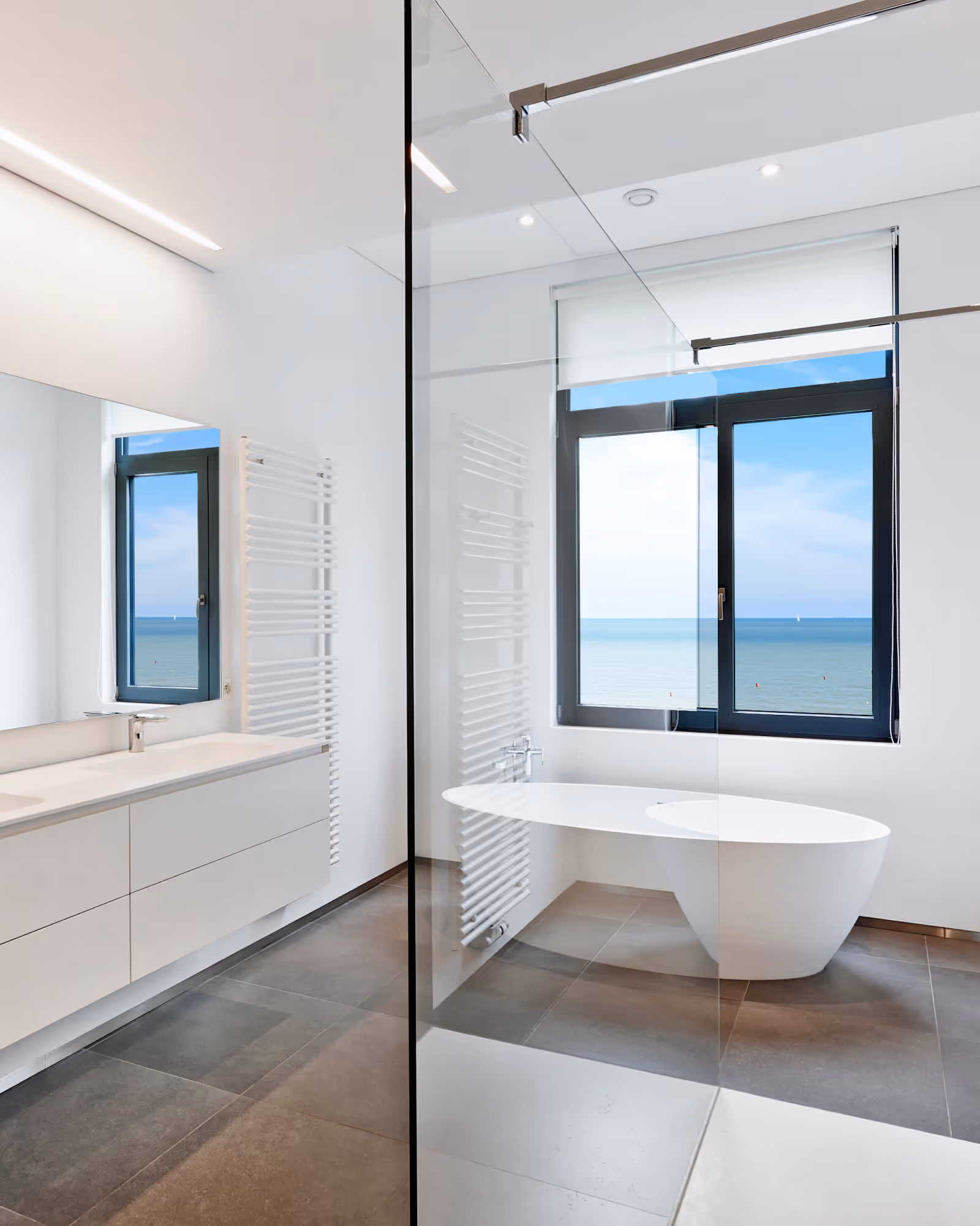 Modern bathroom renovation with freestanding tub, glass shower, and bright natural light