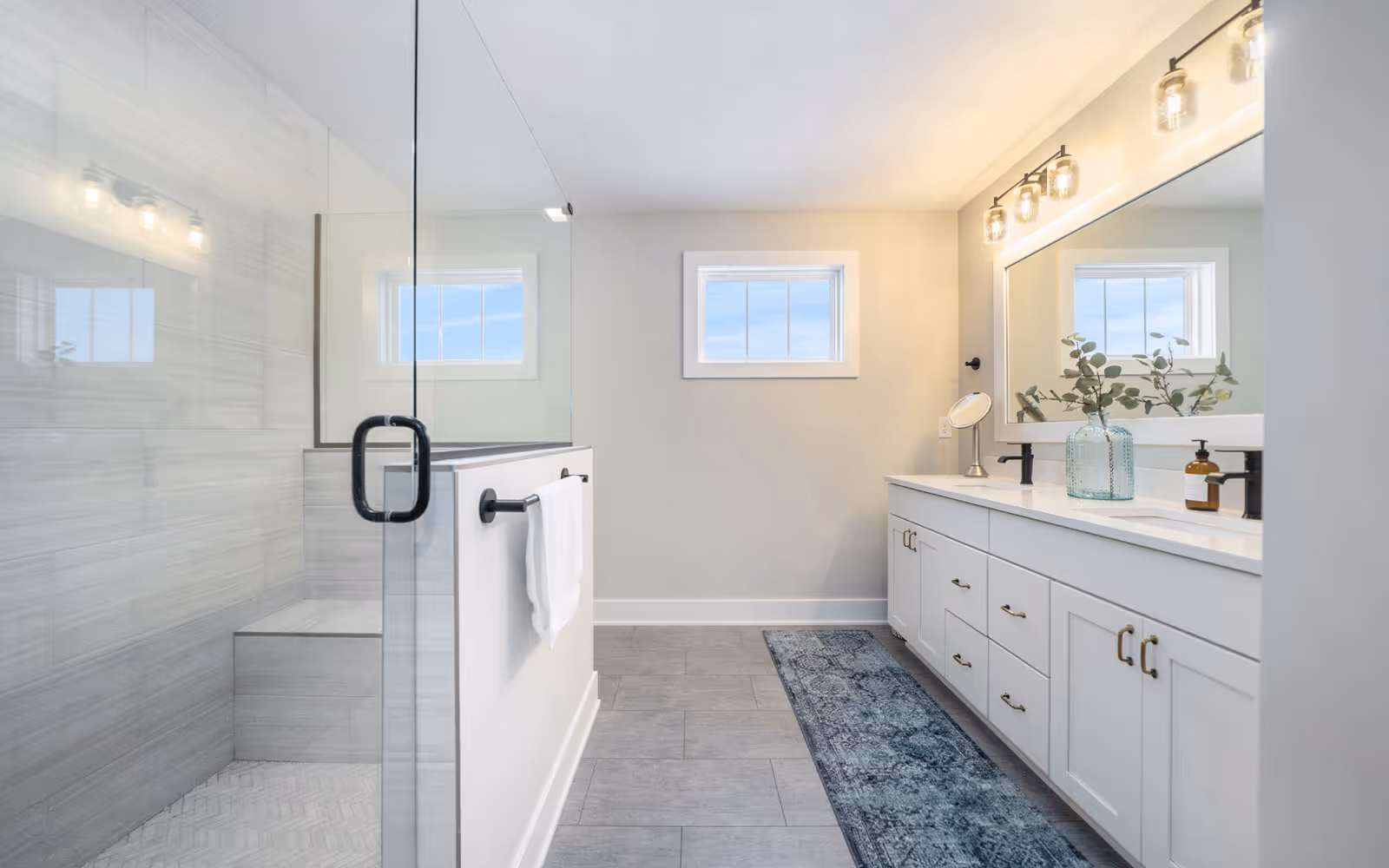 Full bathroom renovation with glass shower, tile walls, and double vanity