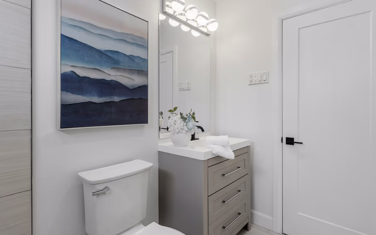 Powder room renovation with compact vanity, modern mirror, and clean finishes