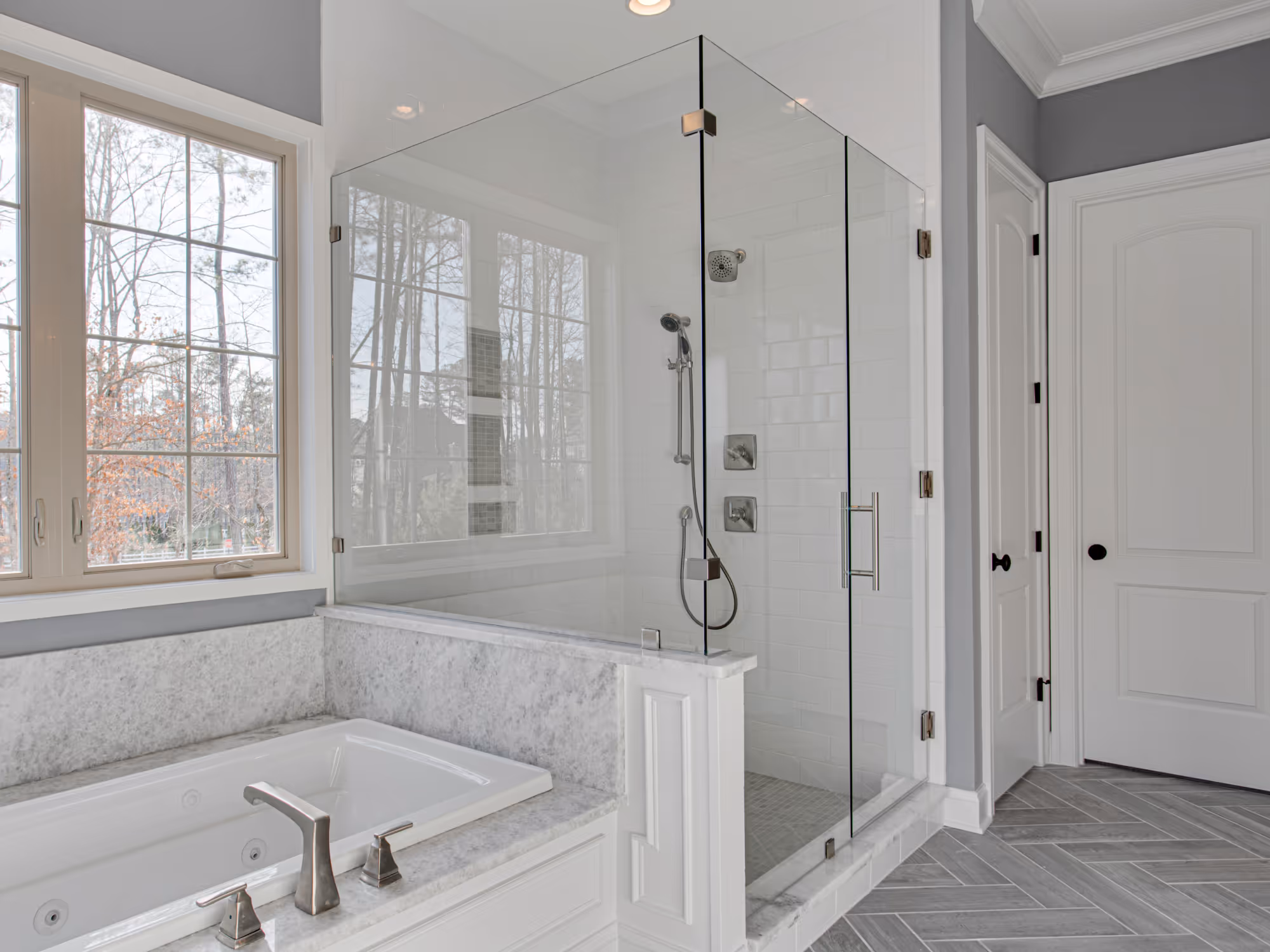 Walk-in shower conversion with frameless glass enclosure and subway tile surround