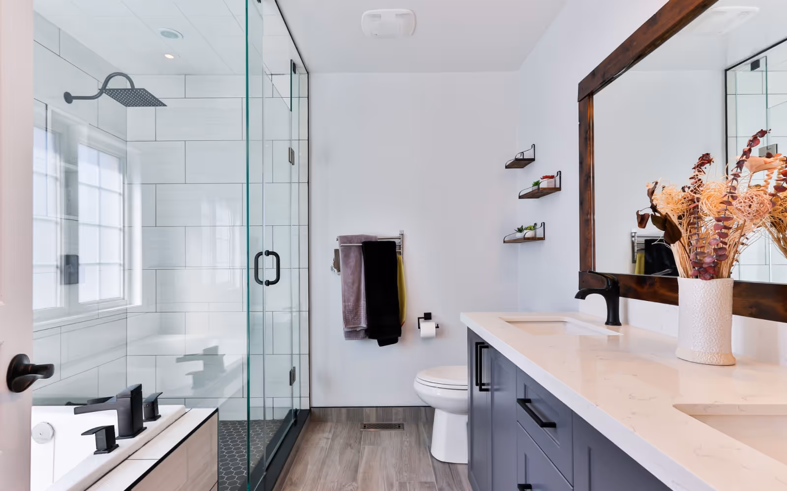Walk-in shower conversion with frameless glass, tiled shower, and updated vanity